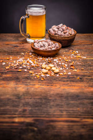Beer and peanuts on the wooden backgroundの写真素材