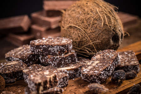 Chocolate dessert, biscuit salami with coconut filings on wooden backgroundの写真素材