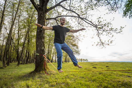 Man slacklining walking and balancing on a rope