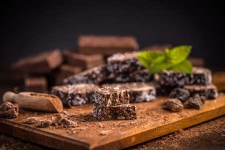 Brown chocolate cake with biscuits on wooden cutting boardの写真素材