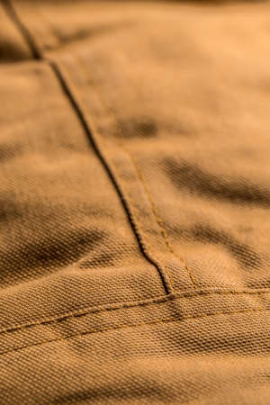 Detail of brown coat with seam stitches