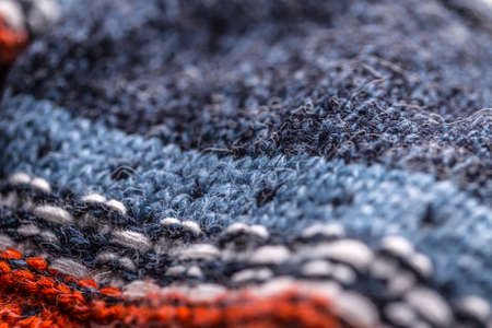 Detail of blue knitted sweater with white and red ornamnet