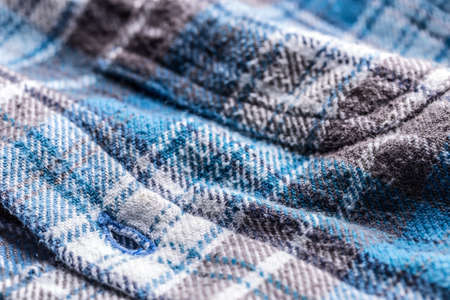 Close up detail of a blue plaid button up style shirt