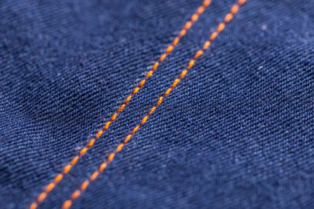 Blue jeans denim texture with orange stitches