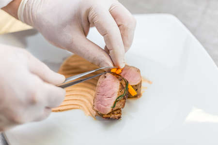 Chef preparing a fine dining meat dishの写真素材