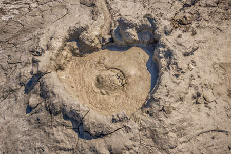 Earth gas reaches the surface through hills making small Mud volcanoesの写真素材