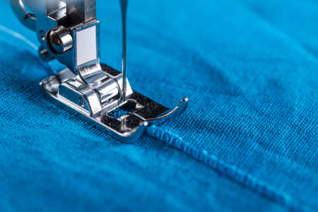 Contemporary sewing machine. Close-up of a presser foot and textile