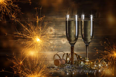 Glasses of champagne with sparkler on backgroundの写真素材