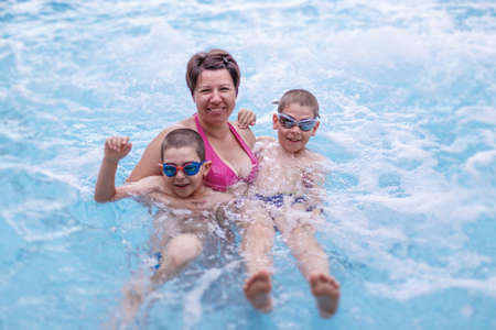 Mother and sons in the swimming poolの写真素材