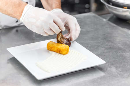 Lamb ribs served on white plate with mashed potato-filled croquettesの写真素材