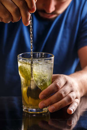Bartender is stirring cocktails on the bar counter