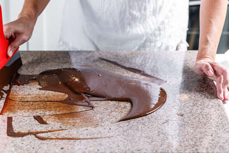 Tempering melted chocolate on tableの写真素材