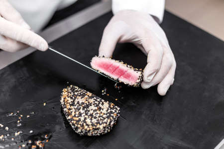 Chef cutting tuna fillet with sesameの写真素材