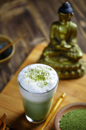 Glass of matcha green tea frappe on wooden table