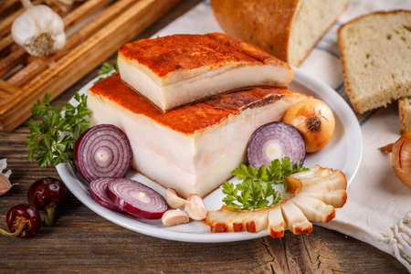 Whole and slice bacon flavored with paprikaの写真素材