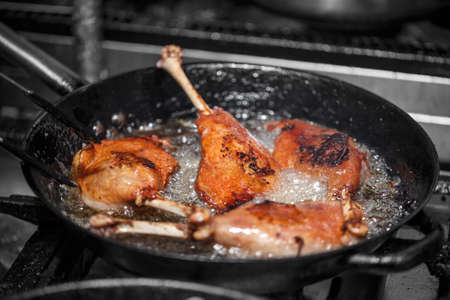 Goose drumstick frying in a pan, restaurant kitchenの写真素材