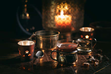 Cup of tea and aromatic candles in the darkの写真素材