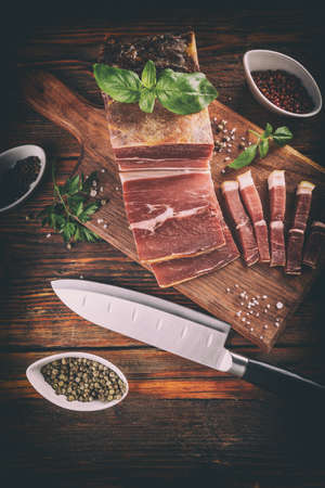 Sliced smoked pork meat on wooden cutting boardの写真素材