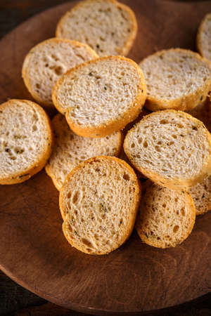 Heap of small rusks on rustic wooden plate