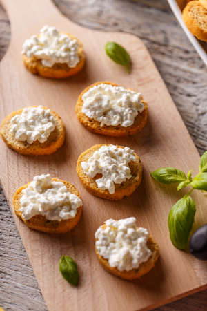 Bruschetta sandwich with cottage cheese on wooden cutting boardの写真素材