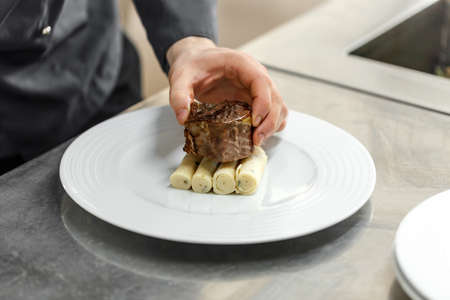 Chef preparing plate for lunch, salted tarragon pancake and roast beef