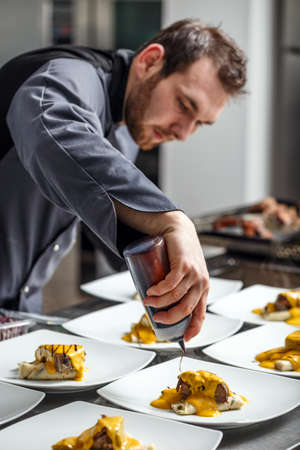 Chef finishing his plate and almost ready to serve at the tableの写真素材
