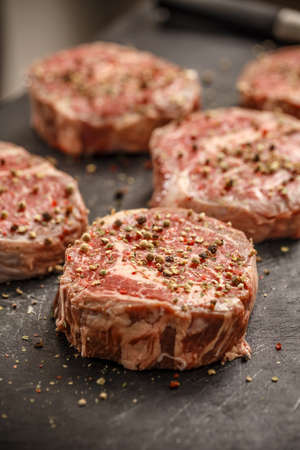 Raw meat steak on dark background ready to roastの写真素材