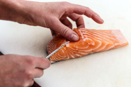 Close up of chef is removing fish bone from salmonの写真素材