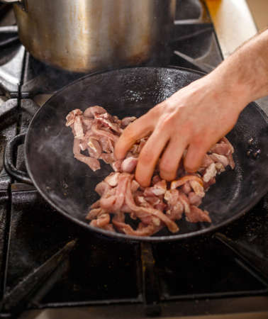 Chef put the meat in a frying panの写真素材