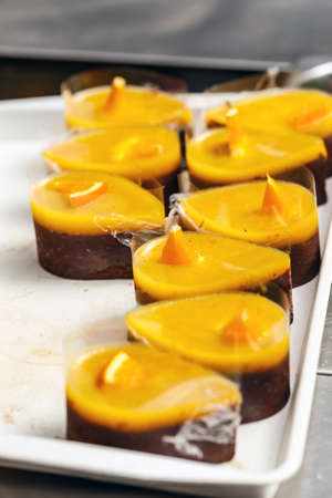 Many chocolate cake with orange sauce on plate