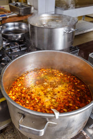 Several pots cooking on hotplate in professional kitchenの写真素材