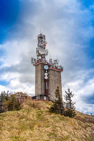 Telecommunication tower with satellite dishes and radio antennas on Postavaru peak, Poiana Brasov,...