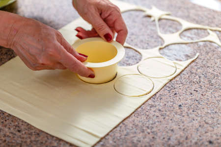Woman hand preparing homemade cookies, cutting dough with moldの写真素材