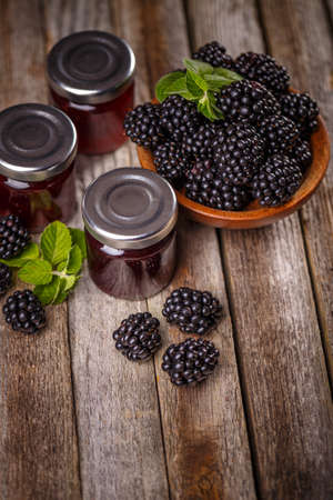 Jars of homemade blackberry jam on a wooden backgroundの写真素材