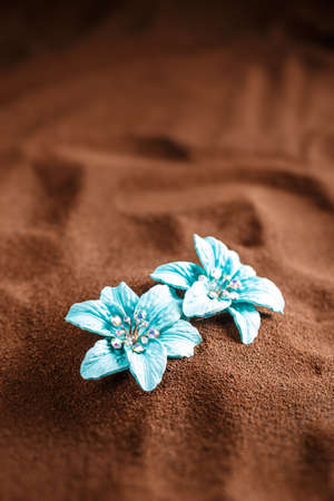Blue jewellery flowers on brown background