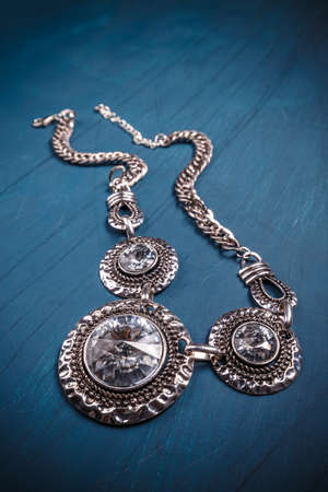 Metal feminine necklace on blue backgroundの写真素材