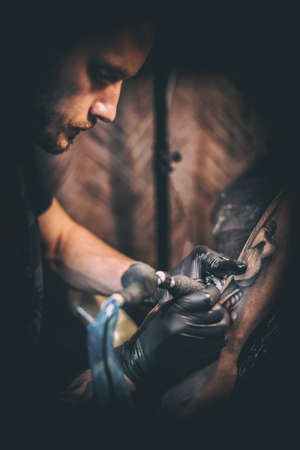 Professional tattooer create tattoo in the salon