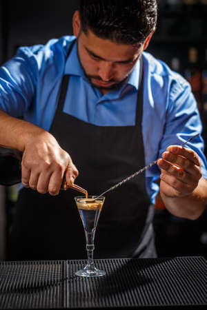 The Bartender makes Brain cocktail in a shot glassの写真素材