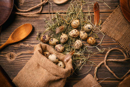 Top view of quail eggs in burlap sack over dark old wooden backgroundの写真素材