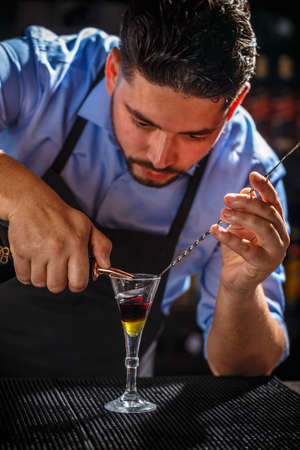 The bartender is preparing layered shot cocktailの写真素材