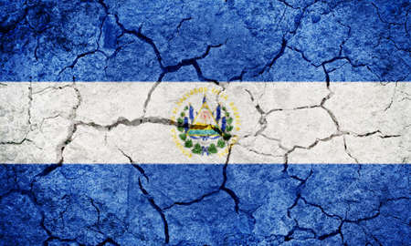Republic of El Salvador flag on dry earth ground texture backgroundの写真素材