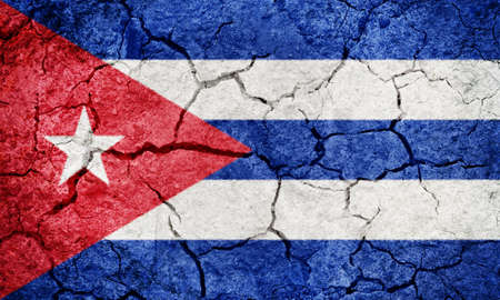 Republic of Cuba flag on dry earth ground texture backgroundの写真素材