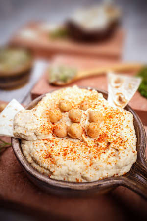  Close up of hummus seasoned with paprika in vintage ceramic plateの写真素材