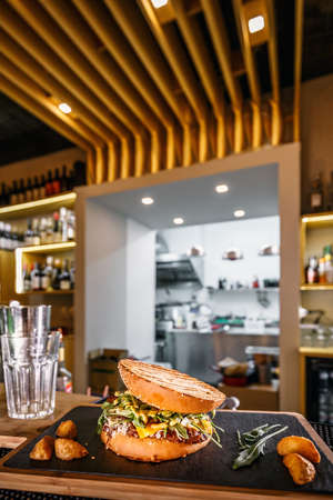 Pulled beef burger with rocket and potato wedges served on pub counterの写真素材