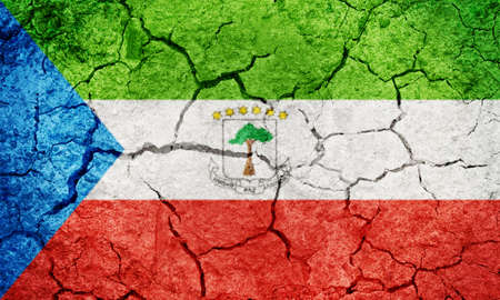 Republic of Equatorial Guinea flag on dry earth ground texture backgroundの写真素材