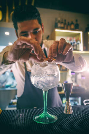 Young male bartender preparing a drink for a customerの写真素材