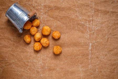 Top view deep fried sweet potato balls on crumpled brown paper backgroundの写真素材