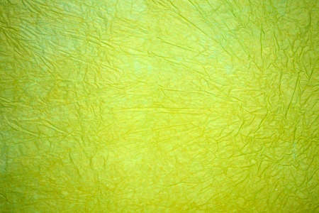 Wrinkled sheet of green paper, light neon green paper backgroundの写真素材