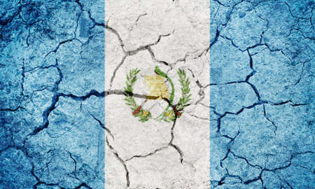 Republic of Guatemala flag on dry earth ground texture backgroundの写真素材