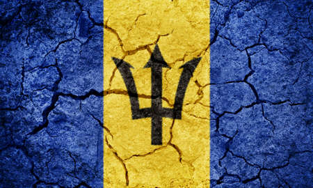 Barbados flag on dry earth ground texture backgroundの写真素材